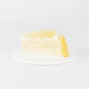 A Lady M Champagne Mille Crêpes slice on top a white round plate.