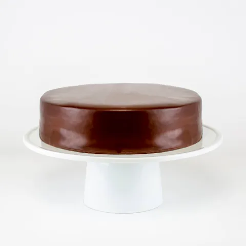 A Lady M Checkers on top a white cake stand.