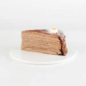 A Lady M Chocolate Banana Mille Crêpes slice on top a white round plate.
