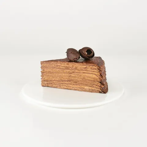 A Lady M Chocolate Mille Crêpes slice on top a white round plate.