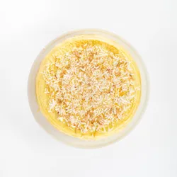 An overhead view of Lady M's Coconut Mille Crêpes topped with coconut flakes.