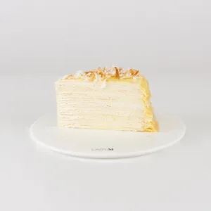 A slice of Lady M's Coconut Mille Crêpes on a white plate.