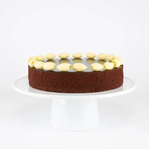 A Lady M Couronne du Chocolat on top a white cake stand.