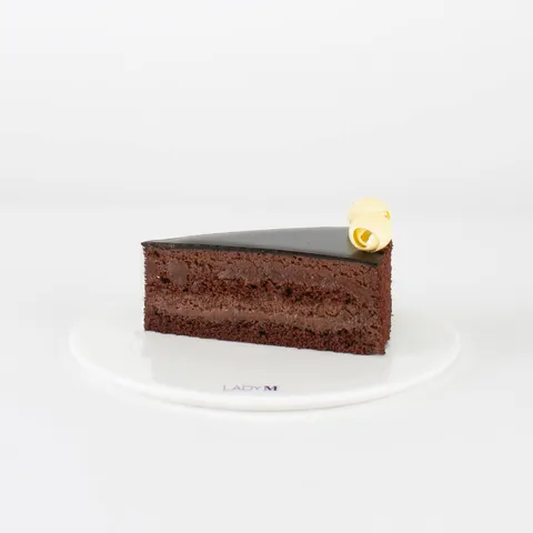 A Lady M Couronne du Chocolat slice on top a white round plate.