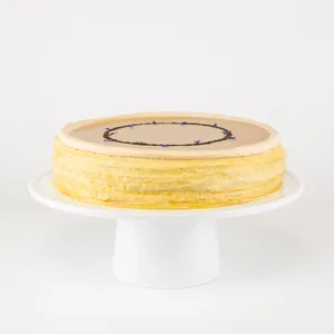 A Lady M Earl Grey Mille Crêpes on top a white cake stand.