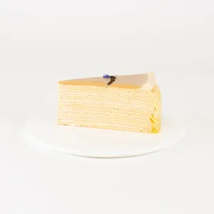 A Lady M Earl Grey Mille Crêpes slice on top a white round plate.