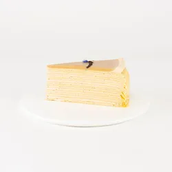 A Lady M Earl Grey Mille Crêpes slice on top a white round plate.
