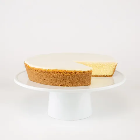 A sliced into Lady M Gâteau Nuage on top a white cake stand.
