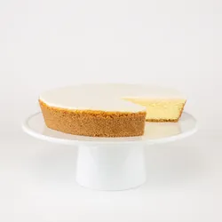 A sliced into Lady M Gâteau Nuage on top a white cake stand.