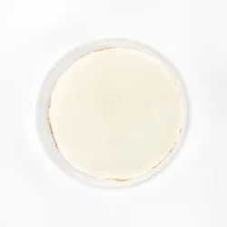 A top-down shot of a Lady M Gâteau Nuage on top a white cake stand.
