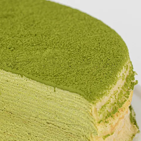 Detail shot of Lady M's Green Tea Mille Crêpes. Layers of crêpe, cream, and matcha powder.