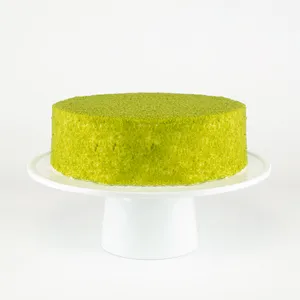 A Lady M Green Tea Mousse Cake on top a white cake stand.