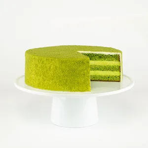 A sliced into Lady M Green Tea Mousse Cake on top a white cake stand.