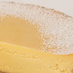 Detail shot of Lady M's Passion Fruit Cheesecake. Graham crust, cream cheese, & passion fruit purée.