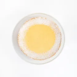 A top-down shot of a Lady M Passion Fruit Cheesecake on top a white cake stand.