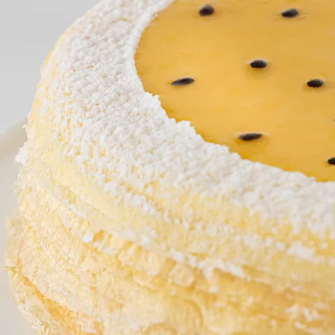 Detail shot of Lady M's Passion Fruit Mille Crêpes. Layers of crêpe, cream, and passion fruit glaze.