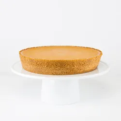 A Lady M Pumpkin Nuage on top a white cake stand.