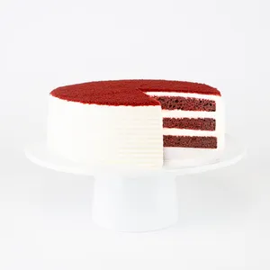 A sliced into Lady M Red Velvet on top a white cake stand.