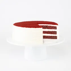 A sliced into Lady M Red Velvet on top a white cake stand.