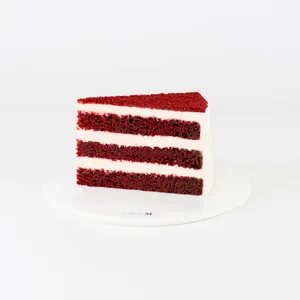 A Lady M Red Velvet slice on top a white round plate.