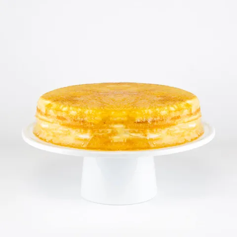A Lady M Signature Mille Crêpes on top a white cake stand.