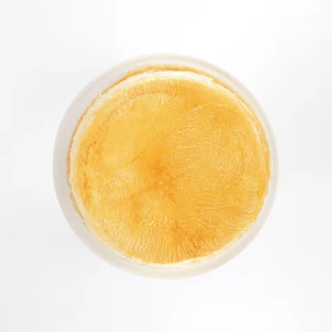 A top-down shot of a Lady M Signature Mille Crêpes on top a white cake stand.