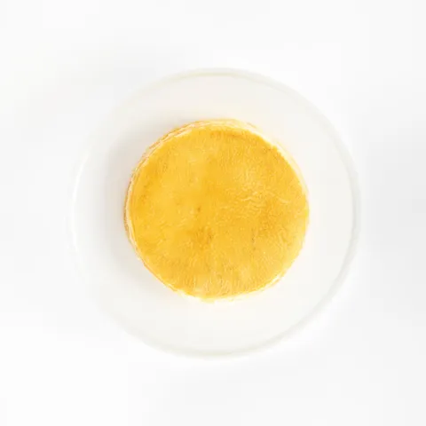 A top-down shot of a 6-inch Lady M Signature Mille Crêpes on top a white cake stand.