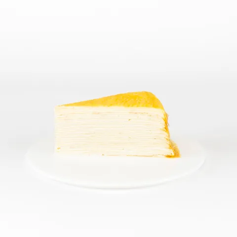 A Lady M Signature Mille Crêpes slice on top a white round plate.