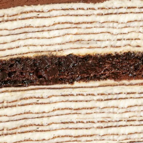 Detail shot of Lady M's Tiramisu Mille Crêpes. Layers of crêpes, sponge cake, and cocoa powder.