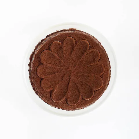 A top-down shot of a Lady M Tiramisu Mille Crêpes on top a white cake stand.