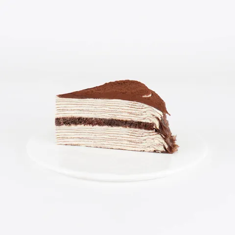 A Lady M Tiramisu Mille Crêpes slice on top a white round plate.