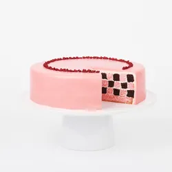 A sliced into Lady M Pink Checkers on top a white cake stand.