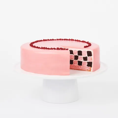 A sliced into Lady M Pink Checkers on top a white cake stand.
