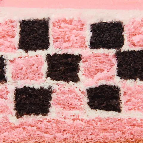 Detail shot of a Lady M Pink Checkers. Layers of sponge cake, cream, glaze, and raspberries.