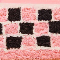 Detail shot of a Lady M Pink Checkers. Layers of sponge cake, cream, glaze, and raspberries.