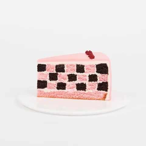 A Lady M Pink Checkers slice on top a white round plate.
