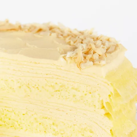 A detail shot of a Lady M Tres Leches Mille Crêpes. Layers of crêpes, cream, and sponge cake.