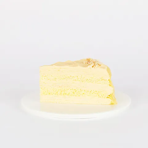 A thumbnail shot of a Lady M Tres Leches Mille Crêpes slice on top a white round plate.