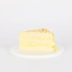 A thumbnail shot of a Lady M Tres Leches Mille Crêpes slice on top a white round plate.