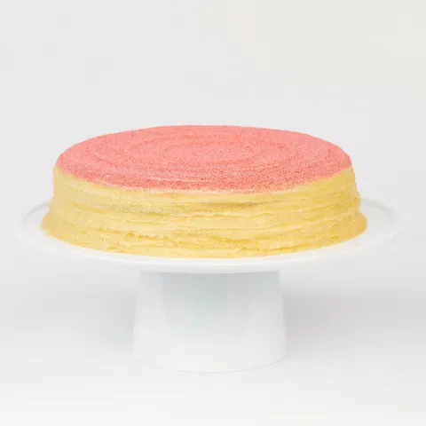 A thumbnail shot of a Lady M Strawberry Swirl Mille Crêpes on top a white cake stand.