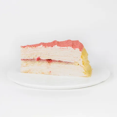 A thumbnail shot of a Lady M Strawberry Swirl Mille Crêpes slice on top a white round plate.