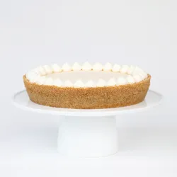 A thumbnail shot of a Lady M Coconut Cheesecake on top a white cake stand.