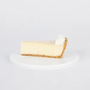 A slice of Lady M's Coconut Cheesecake on a white plate.