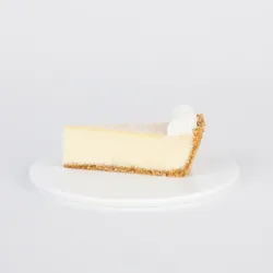 A slice of Lady M's Coconut Cheesecake on a white plate.