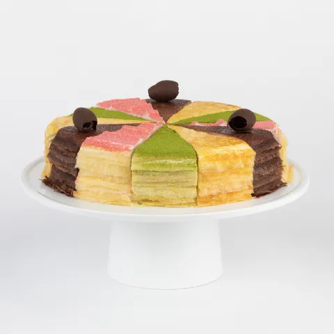 A thumbnail shot of a Lady M Slice of the Best: Summertime Collection on top a white cake stand.