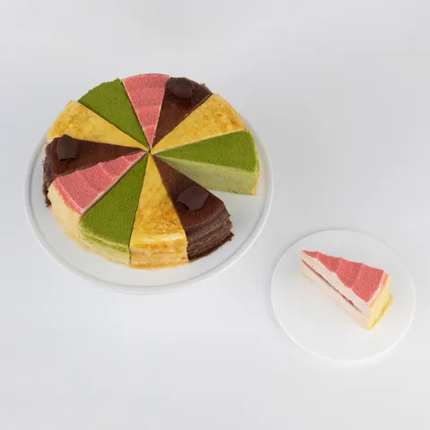 An overhead shot of a Lady M Slice of the Best: Summertime Collection on top a white cake stand.