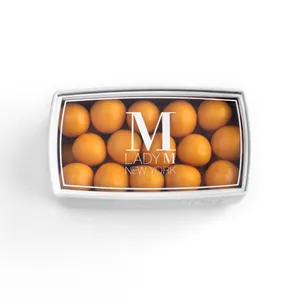 Top-down shot of a Lady M Mango Jelly Pearl Bon Bons encased inside a packaging with a Lady M logo.