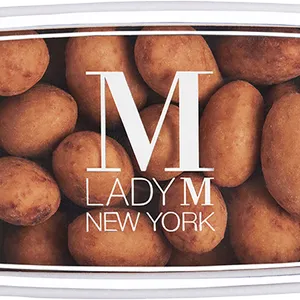 A Lady M Crème Brûlée Almonds Bon Bons encased inside a packaging with a Lady M logo.