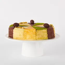 A thumbnail shot of a Lady M Slice of the Best: Celebration Collection on top a white cake stand.
