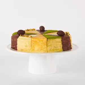 A thumbnail shot of a Lady M Slice of the Best: Celebration Collection on top a white cake stand.